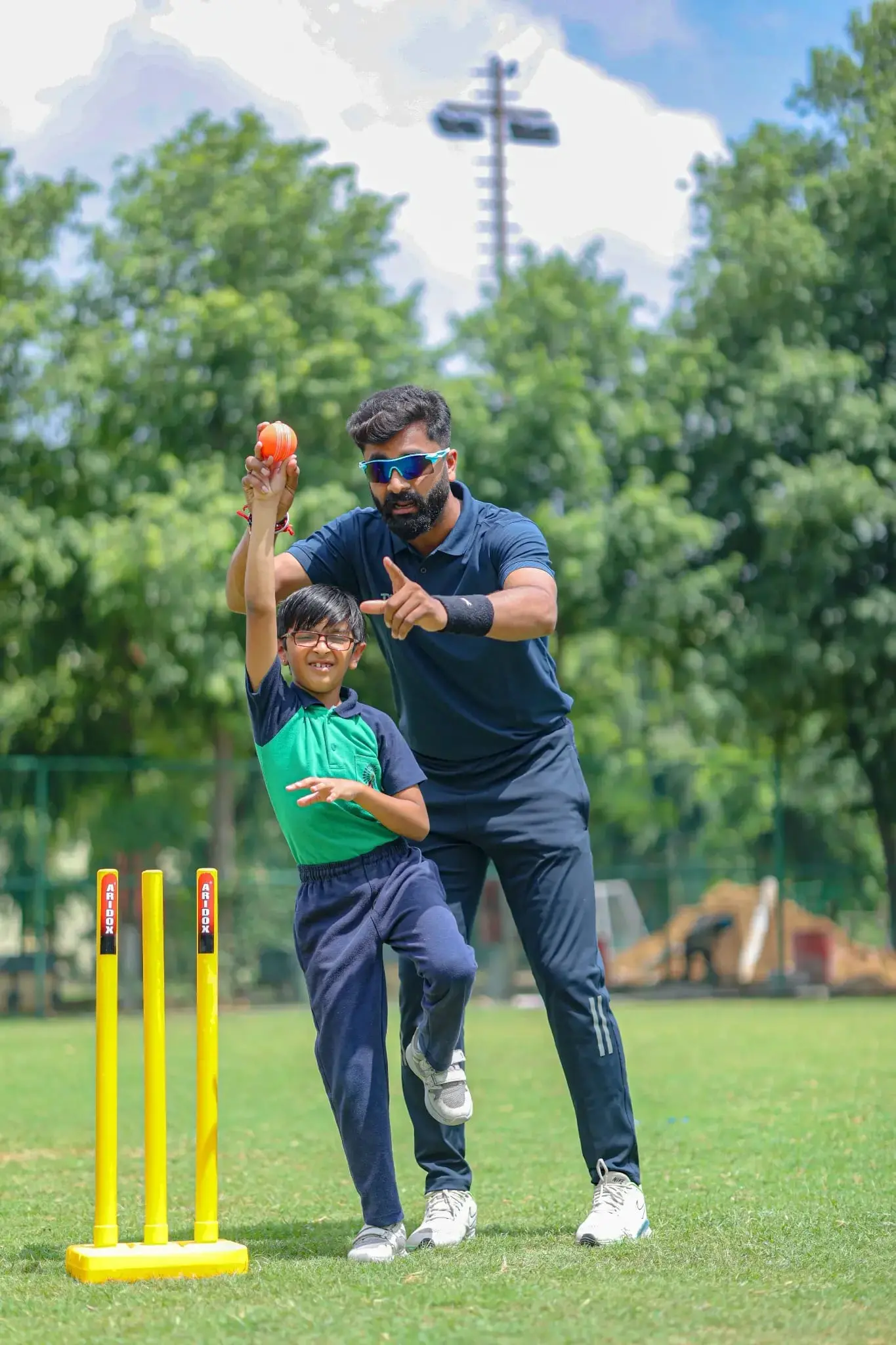 coach is giving guidance to a kid while bowling