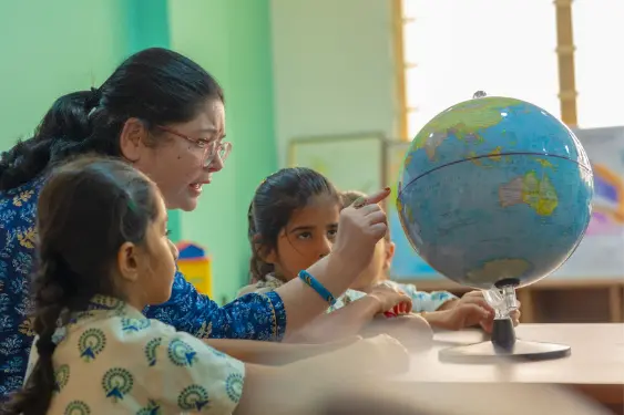teacher teaching the students about World globe